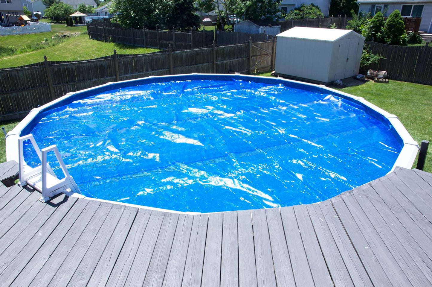 Solar pool cover floating on a round swimming pool, reducing evaporation