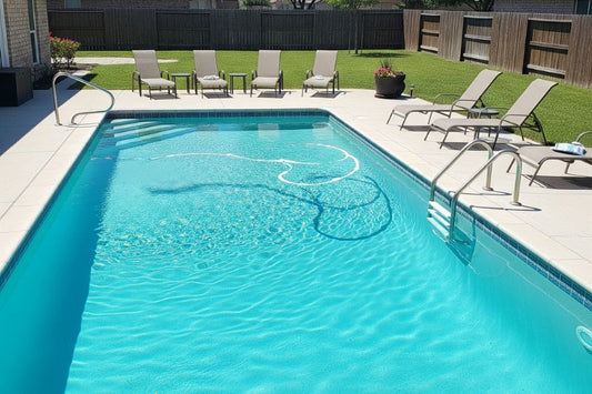 A pristine chlorinated pool shimmers in a sunny suburban backyard.