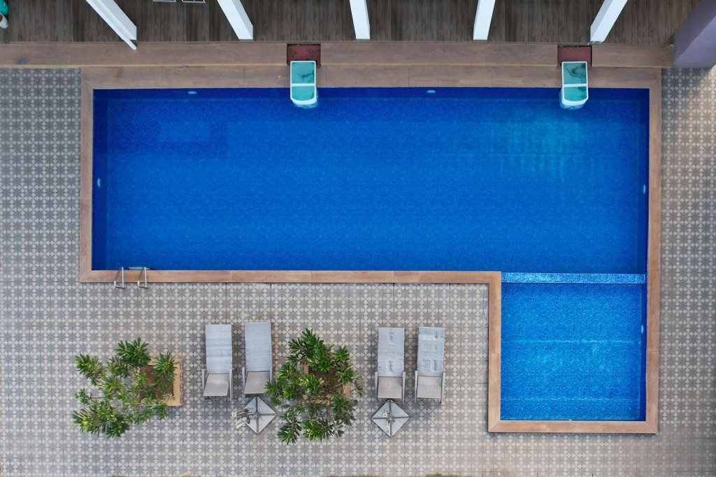 Backyard swimming pool with deck where a cordless robotic pool cleaner could be used